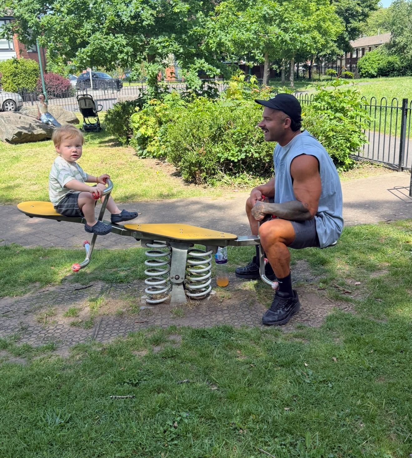 Sam on a seesaw with his son at the park